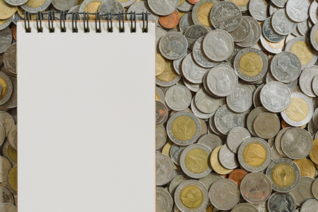 Business finance concept notebook paper on coins backgroundの写真素材