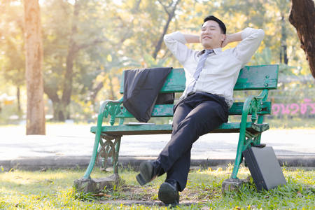 Portrait asian business man sit on a green wooden chairの写真素材