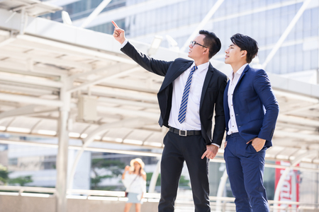 Asian two businessmen happy are working in cityの写真素材