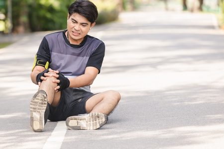 Asian young sport man knee injury from jogging