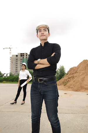 asian men and women engineers work on plans construction  in siteの写真素材
