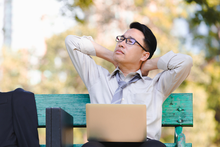 Asian business man working failing serious on laptop in the parkの写真素材
