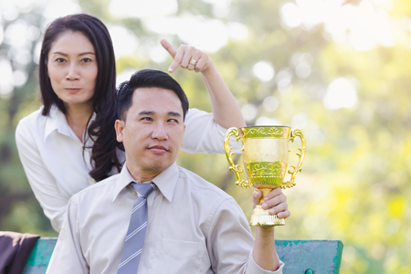 Happy asian business couple associates after receiving awards from work in the park.の写真素材