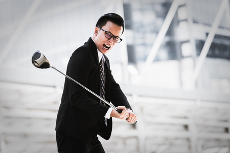 Asian businessman angry with golf Background city. Business conceptの写真素材