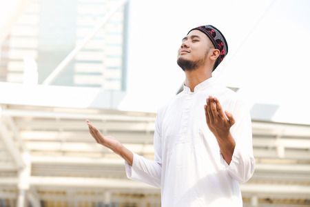 Islam muslim young men praying outdoor in city backgroundの写真素材