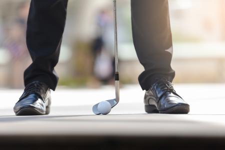 Portrait asian business man holding smartphone and playing golf with background cityscapeの写真素材