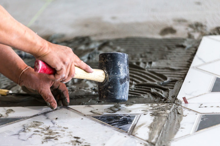 Industrial construction men worker granito tiler builder on floorの写真素材