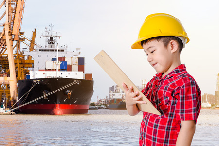 Asian Little boy Shipping working loading containers by crane in ship の写真素材