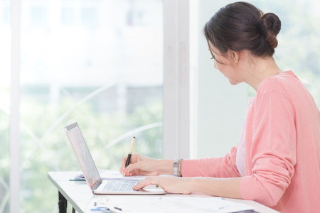 attractive businesswoman sitting working on laptop her small business from homeの写真素材