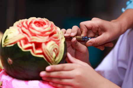 Asian little girl carve fruit in schoolの写真素材