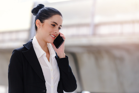 Outdoor young businesswoman worker talking on smartphone. Business conceptの写真素材