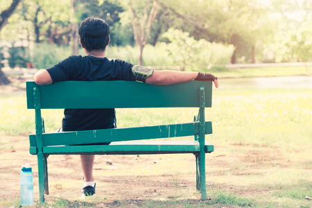 Sport men sitting relaxation in park . Drinking water conceptの写真素材
