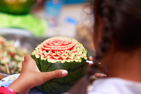 Asian little girl carve fruit in schoolの写真素材