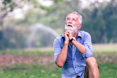 Senior old man Sit down on the grass, plead with God,Health elderly conceptの写真素材