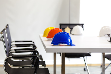 Safety helmet on table in office , engineer concept Teamwork of building construction