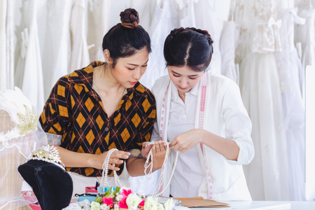 Asian designer working in wedding fashion store shop