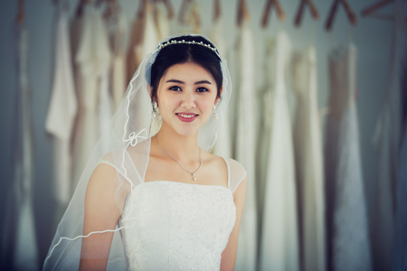 Asian portrait of cute lady smiling happy wearing wedding dressの写真素材
