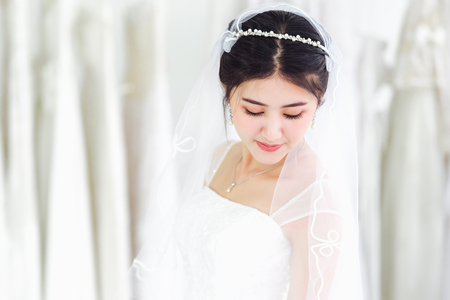 Asian portrait of cute lady smiling happy wearing wedding dressの写真素材
