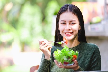 Asian beautiful young girl eating salad vegetable outdoor , Concept healthy bodyの写真素材