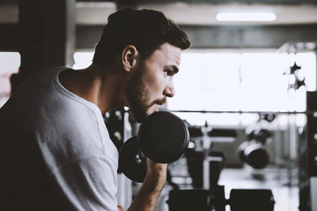 Closeup men healthy holding dumbbell workout and building body at gym fitnessの写真素材