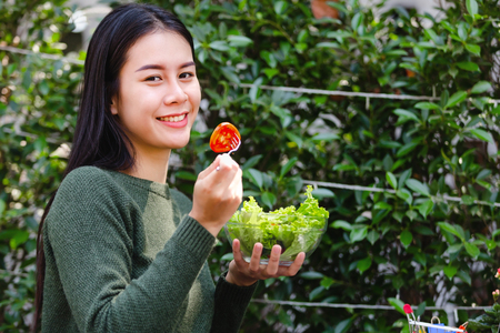 Asian beautiful young girl eating salad vegetable outdoor , Concept healthy bodyの写真素材