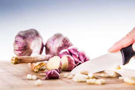 Garlic bulbs on wooden chopping boardの写真素材