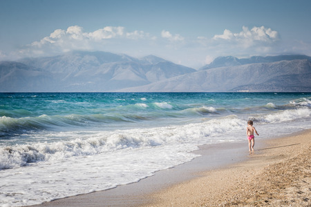Little girl walking by the seaの写真素材