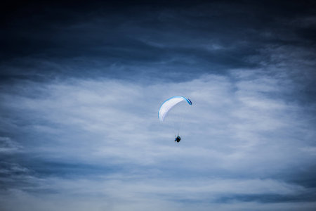 Paraglider soaring in the blue skyの写真素材