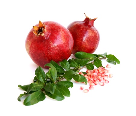 Two pomegranates, pomegranate seeds and twigs on white backgroundの写真素材