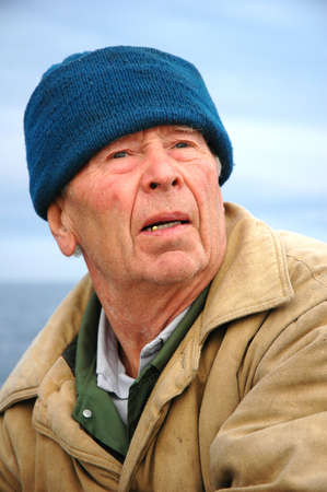 old fisherman fishing on the sea (in boat)の写真素材