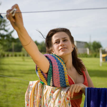 young women (housewife) hang washing on the lineの写真素材