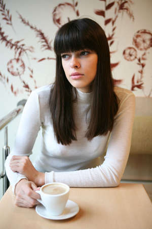 young woman drink the cup of coffee in the cafeの写真素材