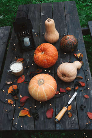 Halloween decorations Pumpkins on wooden table outdoors.