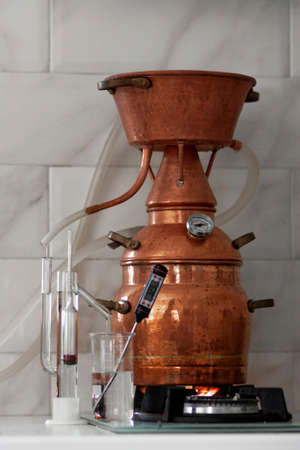 The process of making a strong alcoholic beverage at home. Copper alembic.の写真素材