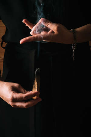 Spiritual practice. Woman holding a piece of scented wood.