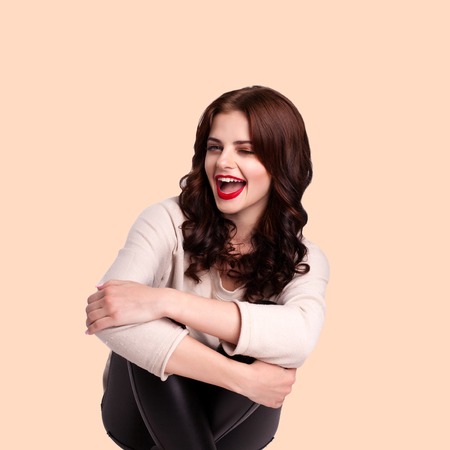 Attractive young girl posing in the studio. Playfully looking at the cameraの写真素材