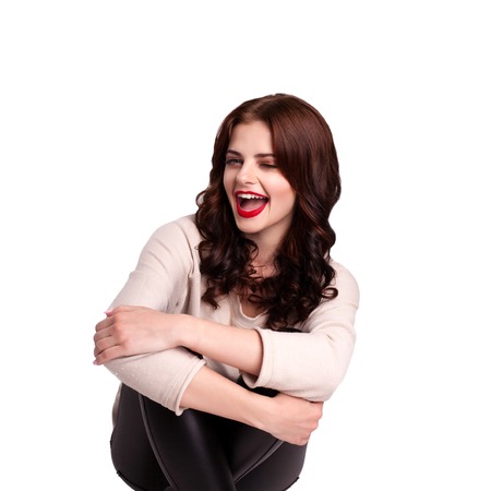 Attractive young girl posing in the studio. Playfully looking at the cameraの写真素材