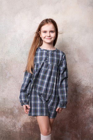 Little girl fooling in the studio, hamming, posing, having fun, enjoying life, carefree childhoodの写真素材