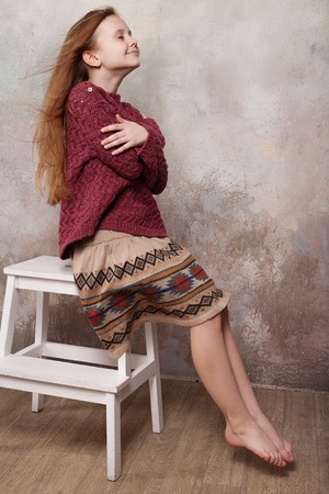 Little girl fooling in the studio, hamming, posing, having fun, enjoying life, carefree childhoodの写真素材