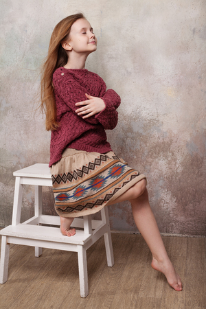 Little girl fooling in the studio, hamming, posing, having fun, enjoying life, carefree childhoodの写真素材