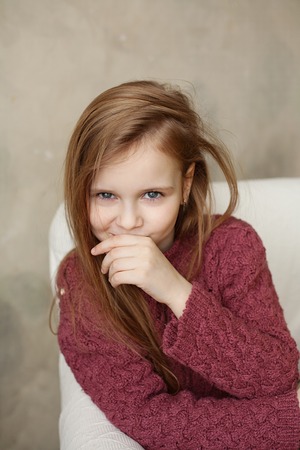 Little girl fooling in the studio, hamming, posing, having fun, enjoying life, carefree childhoodの写真素材