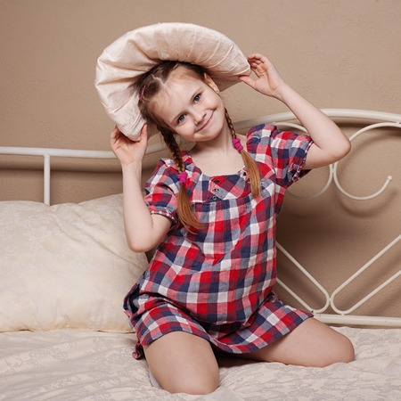 Little girl fooling in the studio, hamming, posing, having fun, enjoying life, carefree childhoodの写真素材