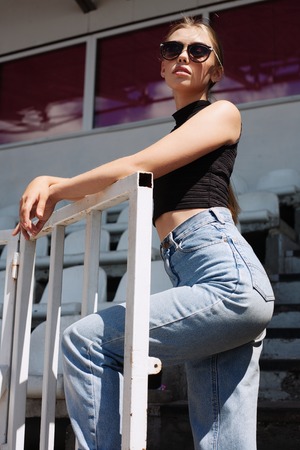 Hipster girt posing at the stadium. Outdoors lifestyle portraitの写真素材