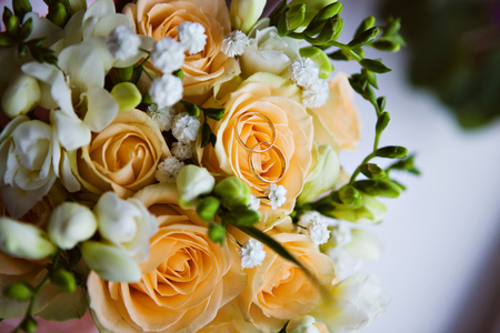 Wedding rings on a bouquet of rosesの写真素材