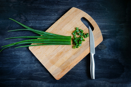 Onions on a board with a knifeの写真素材