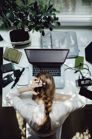 Exhausted young Caucasian woman work on laptop at home suffer from dizziness, tired millennial female struggle with migraine or headache overwhelmed with computer job.の写真素材