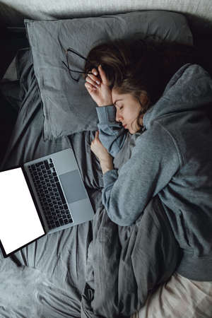 While working using laptop, lady fall asleep on remote project in bedroom. Burnout Syndrome....