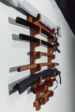 Special stand on the white wall for training swords made of oak wood and iron. Traditional Japanese...