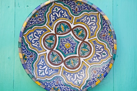 Traditionaly painted ceramic plate displayed at the wooden wall.の写真素材
