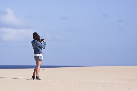 Atractive girl  taking photograph of the sand dunes on Fuerteventura, Canary Islandsの写真素材